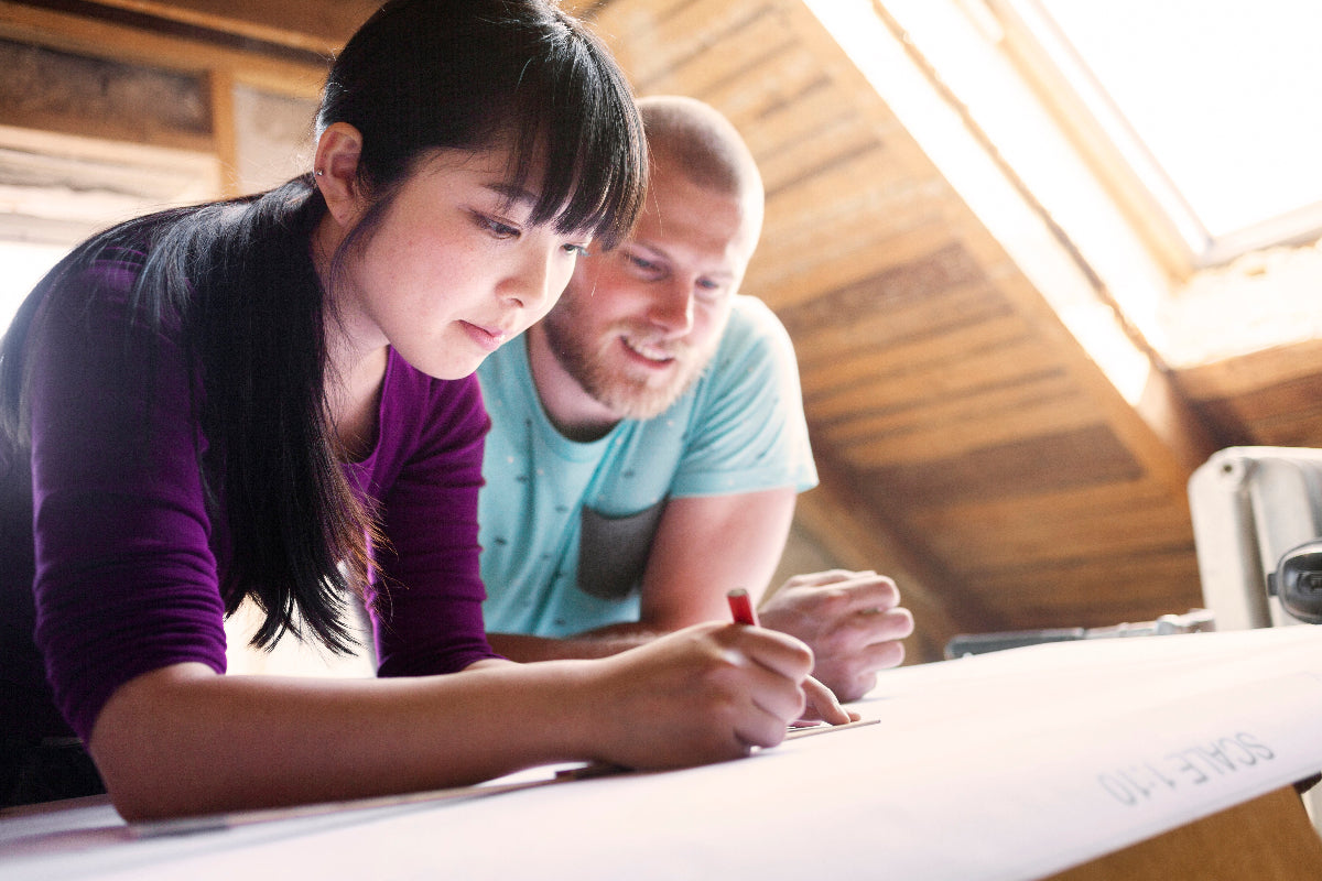 Two people working together on a project at a table.
