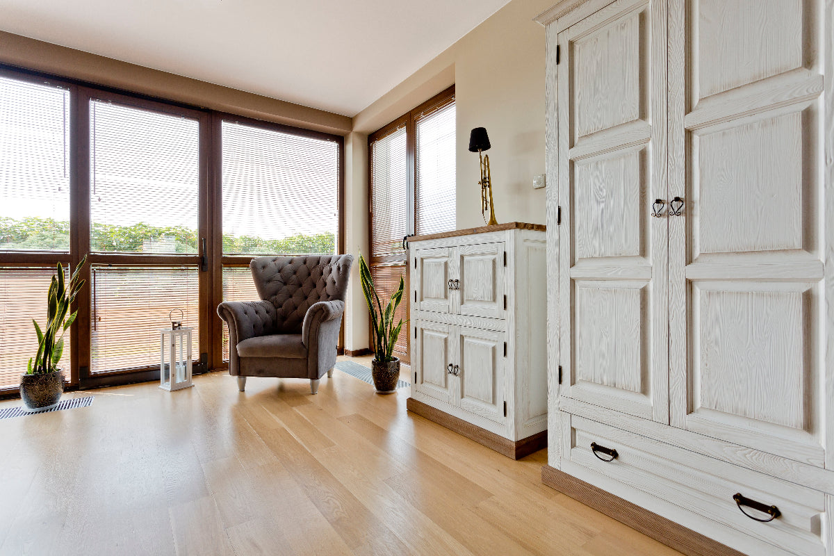Modern interior with a white wardrobe, armchair, and decorative items.