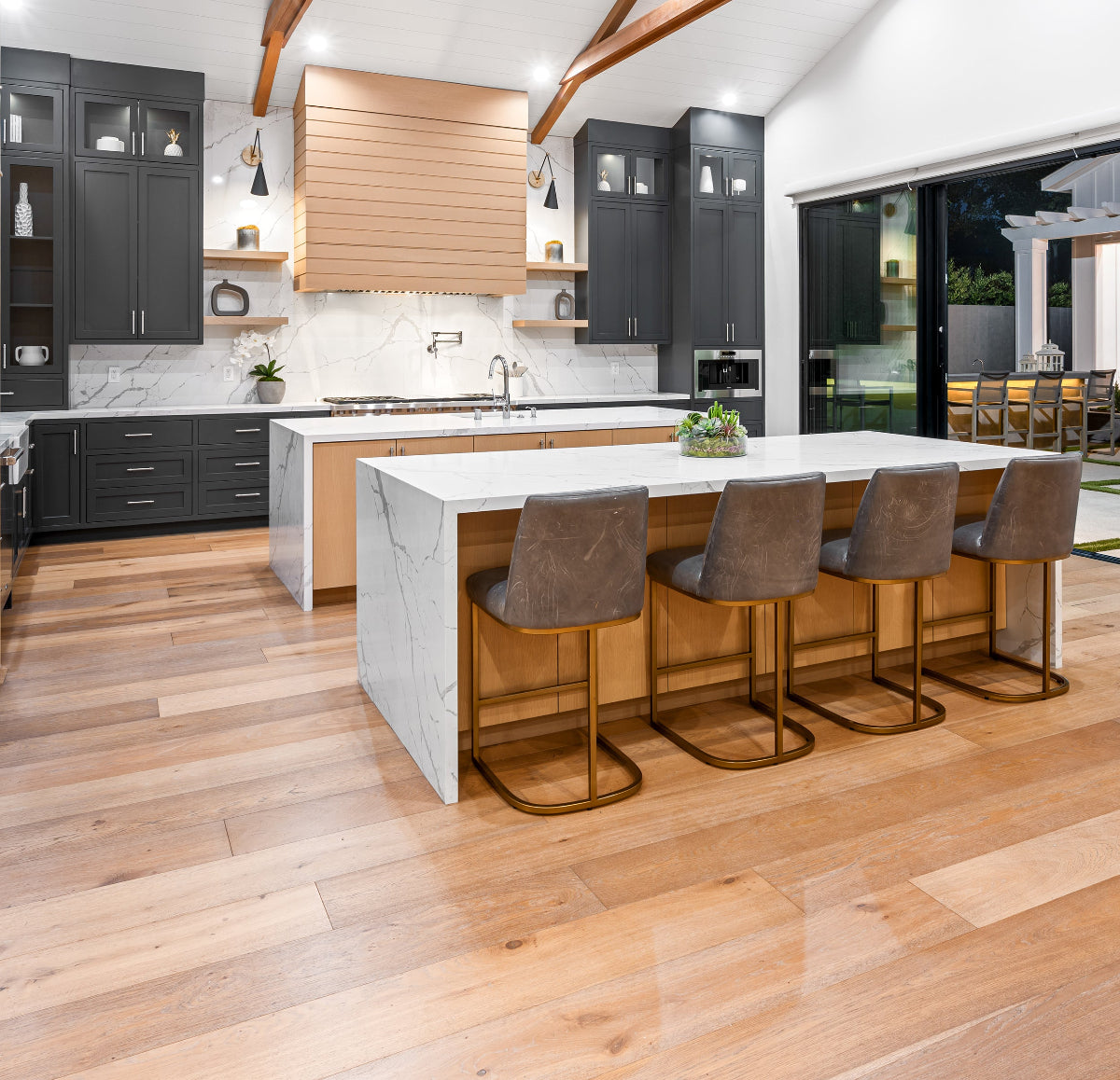 Modern kitchen with marble island and bar stools on a wooden floor
